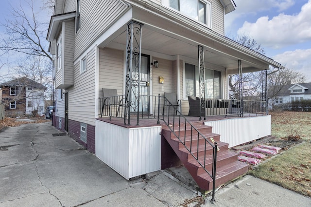 view of exterior entry featuring covered porch