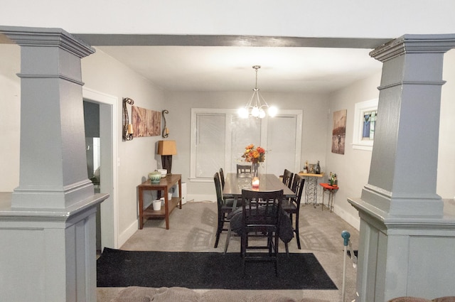 dining area with decorative columns, light carpet, and an inviting chandelier