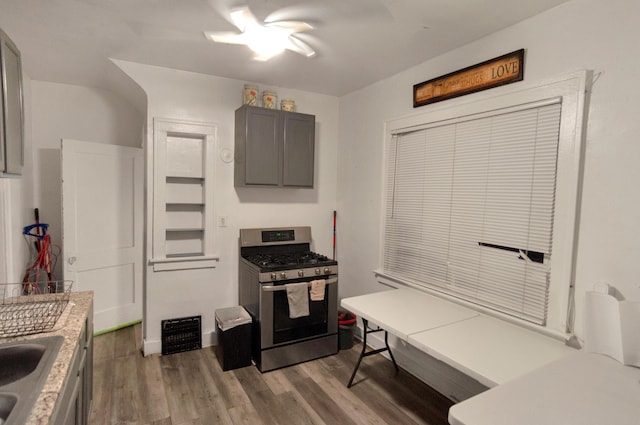 kitchen featuring gray cabinetry, stainless steel range with gas cooktop, and light wood-type flooring