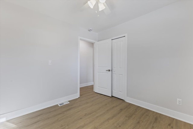 unfurnished bedroom with ceiling fan, light hardwood / wood-style floors, and a closet