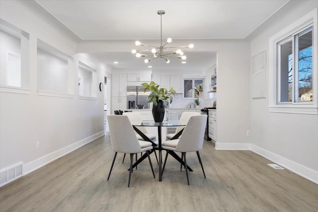 dining space featuring a chandelier and light hardwood / wood-style floors