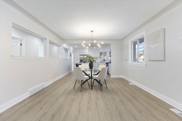 dining space featuring a chandelier and light hardwood / wood-style floors