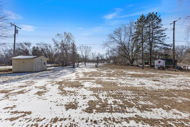 yard covered in snow with a storage shed