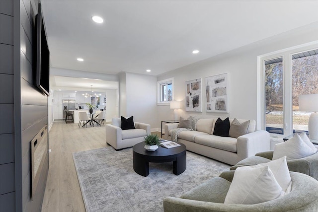 living room featuring a notable chandelier and light wood-type flooring