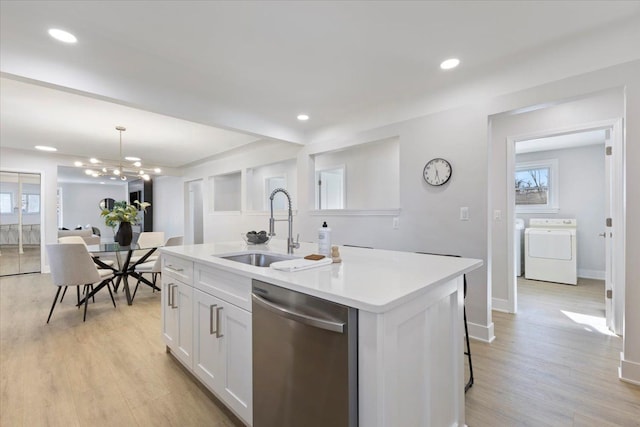 kitchen with dishwasher, a kitchen island with sink, white cabinets, sink, and decorative light fixtures