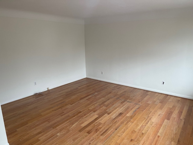 unfurnished room with baseboards and wood finished floors