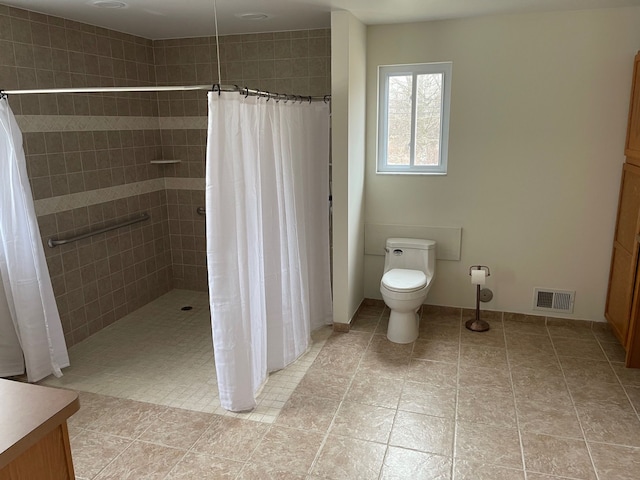 bathroom featuring visible vents, toilet, tile patterned floors, walk in shower, and vanity