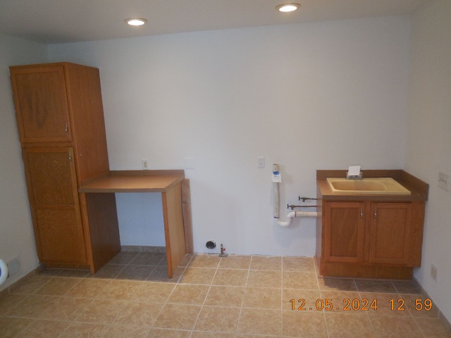 laundry room with light tile patterned floors, a sink, and recessed lighting