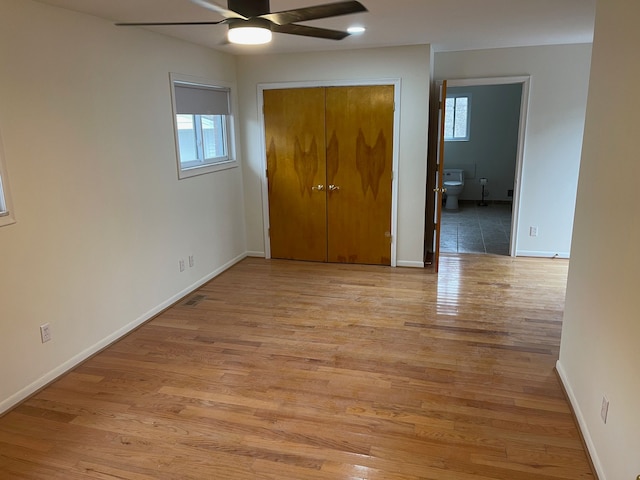 unfurnished bedroom with light wood finished floors, multiple windows, and baseboards