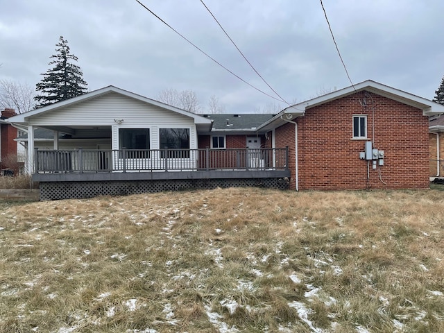 rear view of property with a deck and brick siding