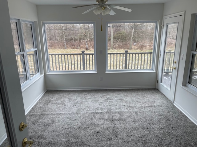 unfurnished sunroom featuring ceiling fan