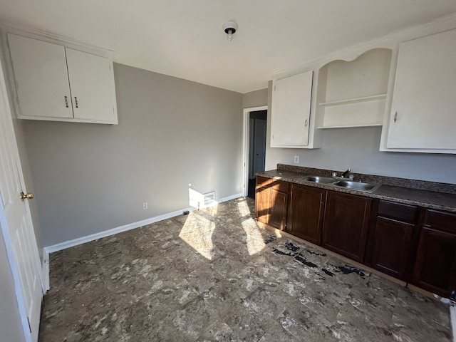 kitchen featuring white cabinets, dark brown cabinets, and sink