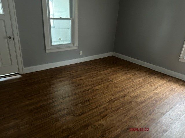 empty room with dark hardwood / wood-style flooring