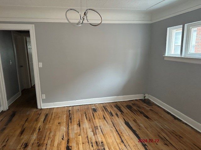 unfurnished dining area with dark hardwood / wood-style flooring and crown molding