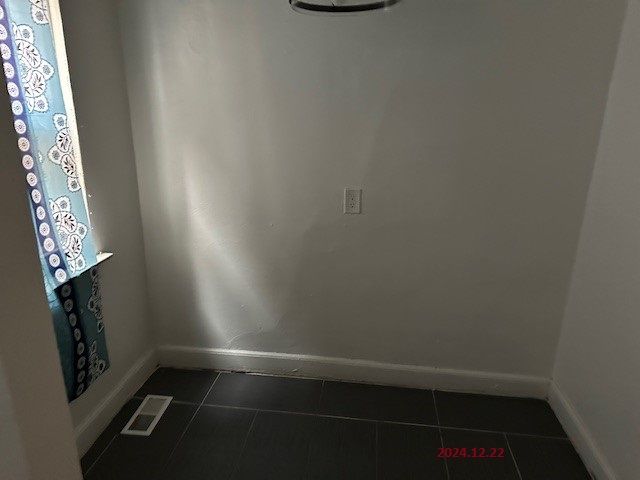 unfurnished room featuring dark tile patterned floors