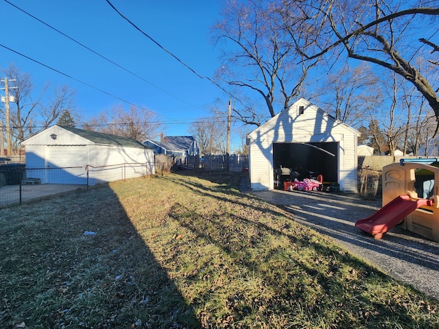 view of yard with a garage and an outbuilding