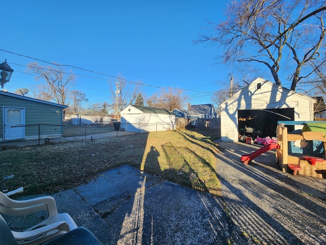 view of yard featuring a garage and an outbuilding