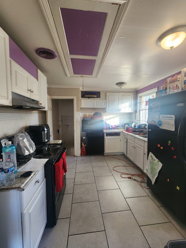 kitchen featuring light tile patterned flooring, white cabinets, and black appliances