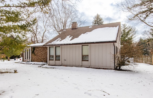 view of snow covered rear of property