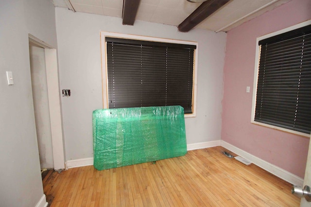 misc room with hardwood / wood-style flooring and beamed ceiling