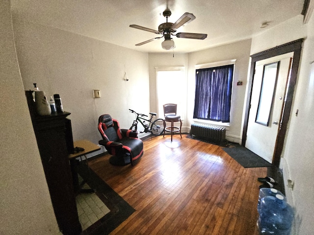 sitting room featuring wood-type flooring, radiator, and ceiling fan