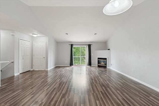 unfurnished living room featuring dark hardwood / wood-style floors and vaulted ceiling