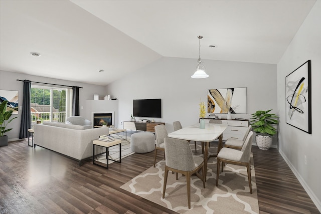 dining space featuring dark hardwood / wood-style floors and vaulted ceiling