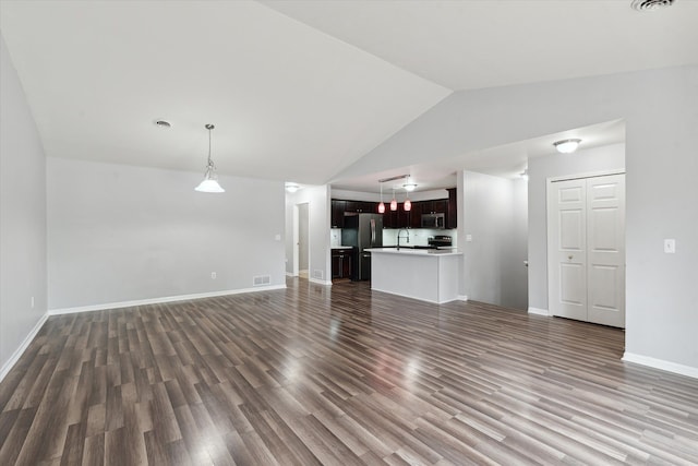 unfurnished living room with sink, lofted ceiling, and dark wood-type flooring