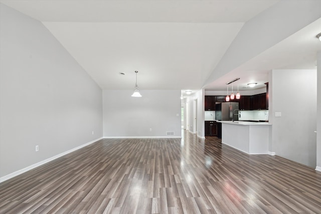 unfurnished living room featuring dark hardwood / wood-style floors, lofted ceiling, and sink