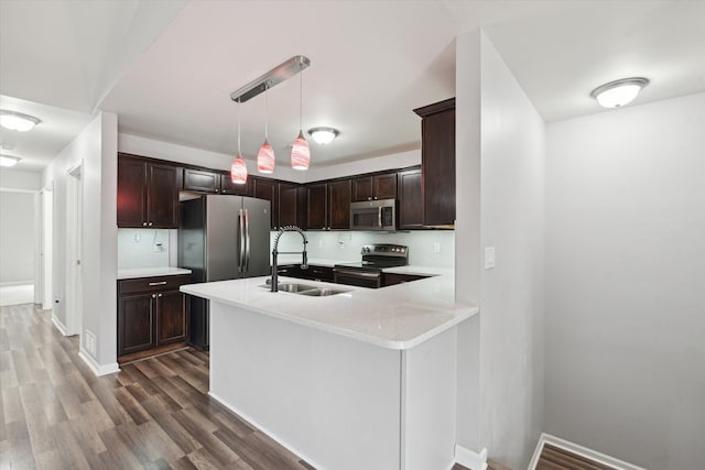 kitchen with pendant lighting, backsplash, stainless steel appliances, and sink