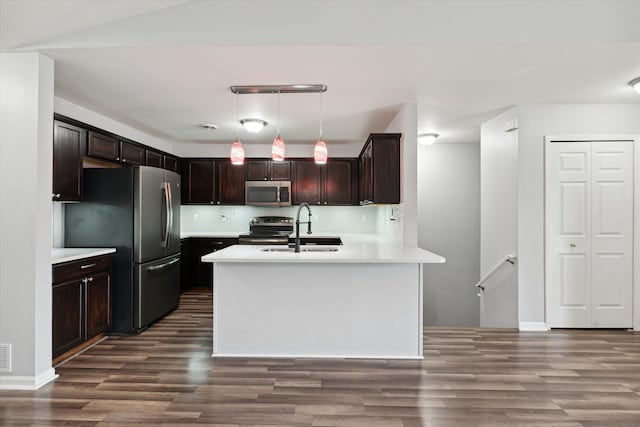 kitchen with backsplash, sink, hanging light fixtures, appliances with stainless steel finishes, and dark hardwood / wood-style flooring