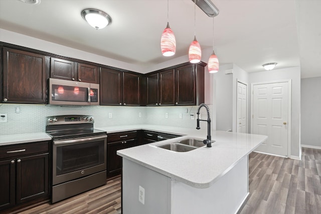 kitchen with dark brown cabinetry, sink, hanging light fixtures, and appliances with stainless steel finishes