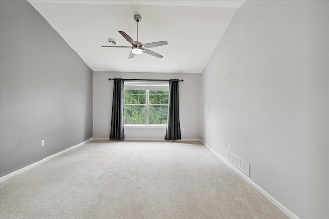 empty room featuring ceiling fan, light colored carpet, and lofted ceiling