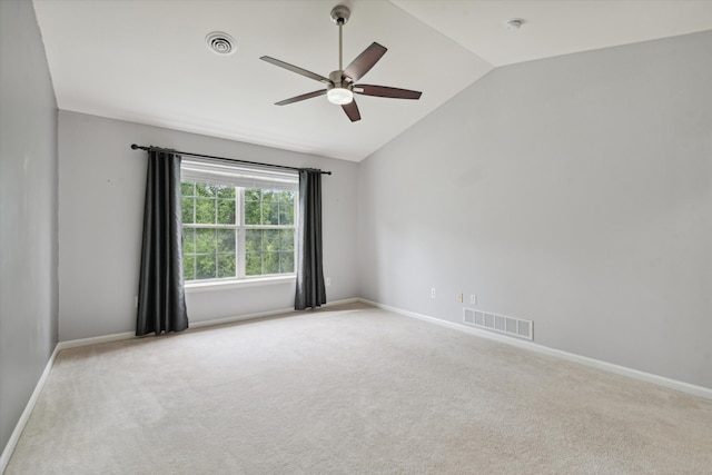 empty room with ceiling fan, light colored carpet, and vaulted ceiling