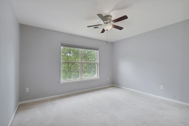 spare room featuring light colored carpet and ceiling fan