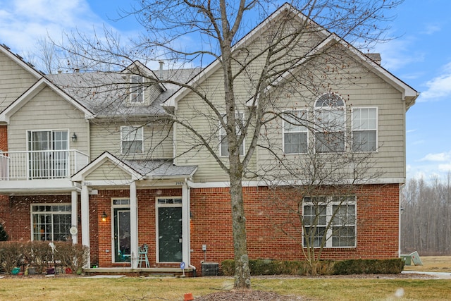 view of front facade featuring a balcony and a front lawn