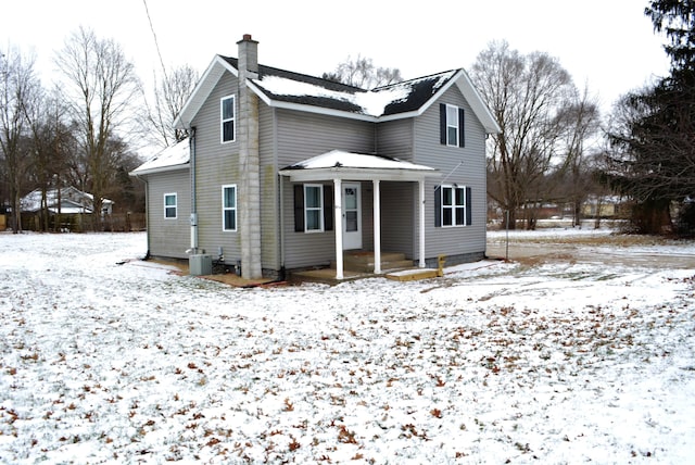 snow covered house with central AC unit