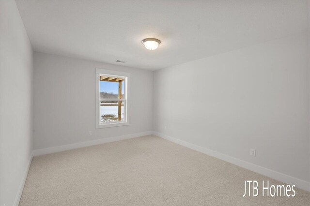 unfurnished room with baseboards, carpet, and visible vents