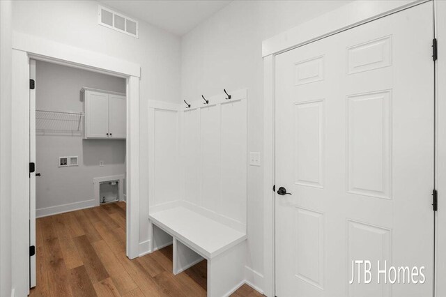 mudroom with visible vents, baseboards, and wood finished floors