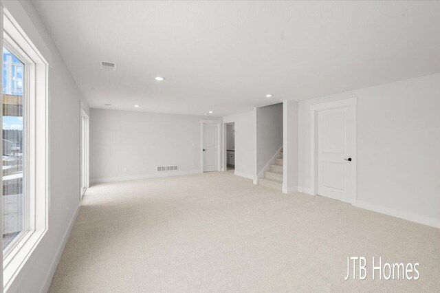 interior space featuring light colored carpet, recessed lighting, and visible vents