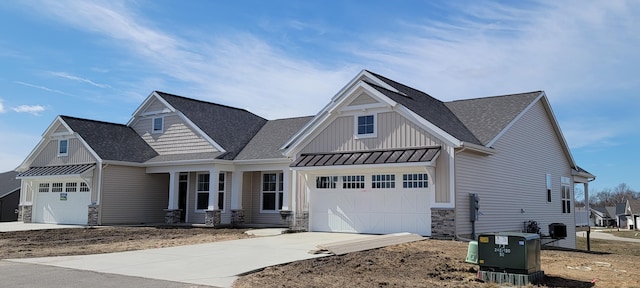 view of front of property with concrete driveway, stone siding, roof with shingles, a standing seam roof, and board and batten siding