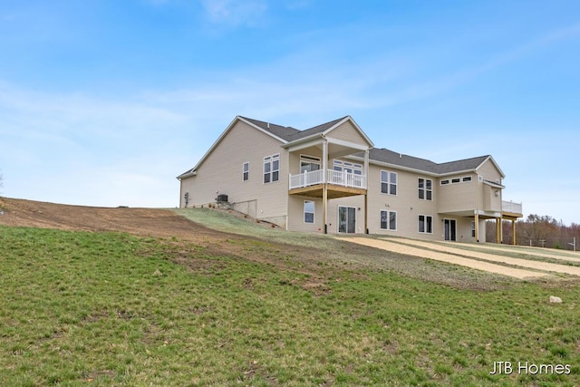 rear view of property featuring a yard and a balcony