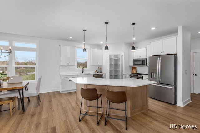 kitchen featuring recessed lighting, light wood-type flooring, backsplash, and stainless steel appliances