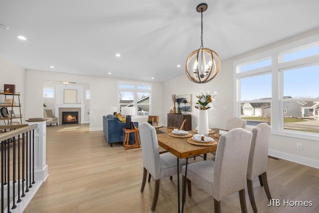 dining room with recessed lighting, light wood-type flooring, and an inviting chandelier