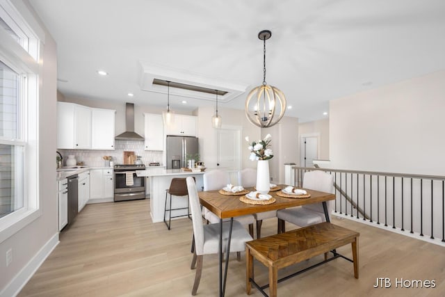 dining space with recessed lighting, baseboards, a notable chandelier, and light wood finished floors