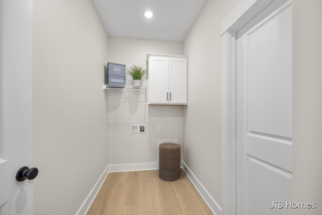 washroom featuring cabinet space, hookup for a washing machine, light wood-style floors, and baseboards