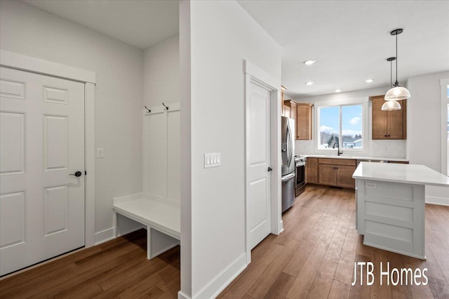 mudroom with a sink, light wood-type flooring, baseboards, and recessed lighting