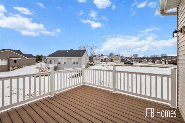 snow covered deck with a residential view