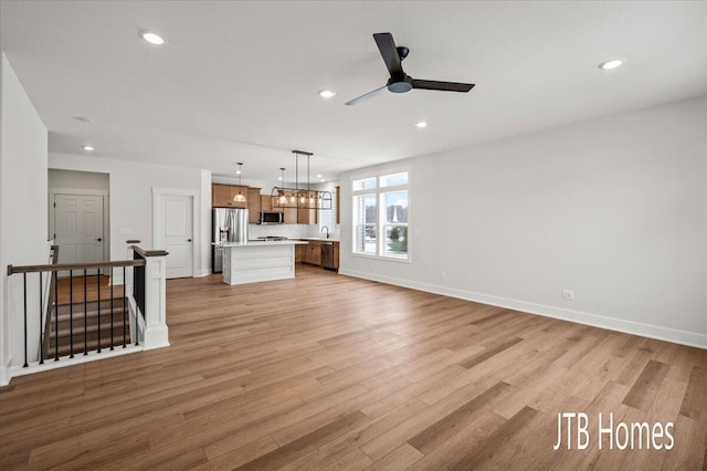 unfurnished living room with baseboards, recessed lighting, a ceiling fan, and light wood-style floors