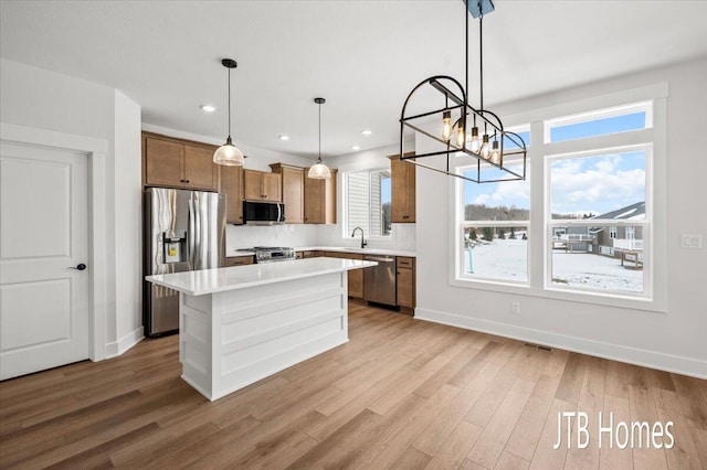 kitchen featuring a sink, light countertops, light wood-style flooring, and stainless steel appliances